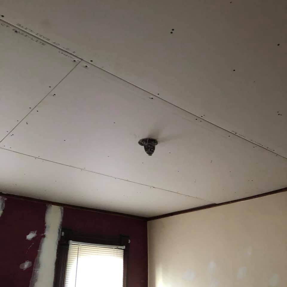 new drywall hung on ceiling of home with wood trim